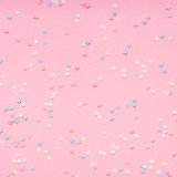 Little stars confetti on pink background. Holyday concept.