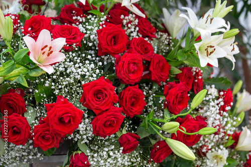 Strau   mit roten Rosen und Lilien mit Schleierkraut