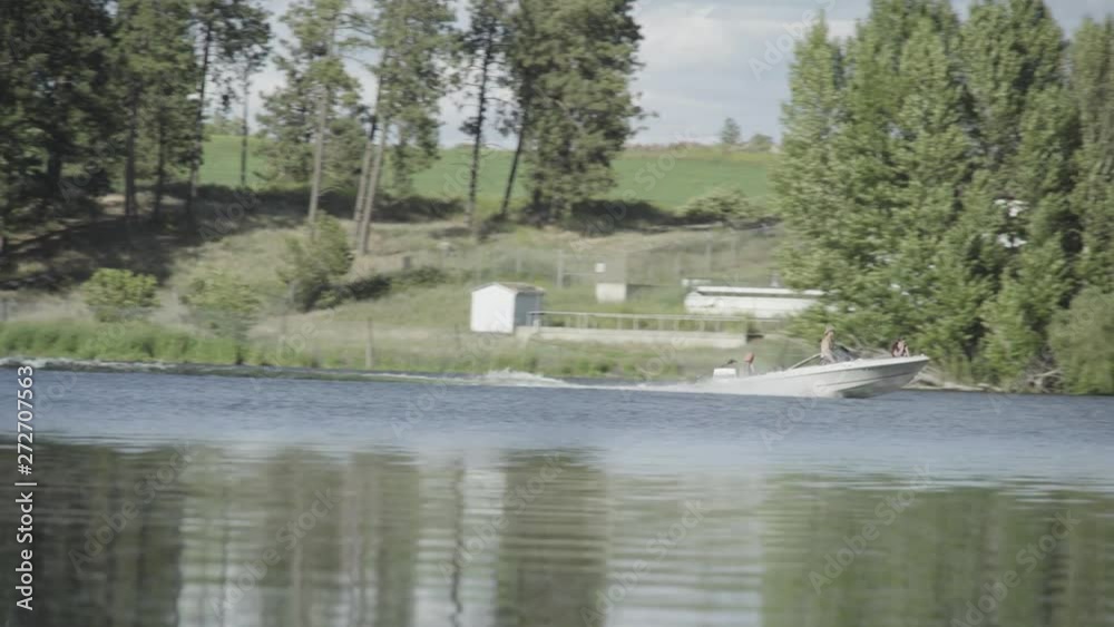 Boat cruises on lake with view of shoreline Boat cruises on lake with view of shoreline