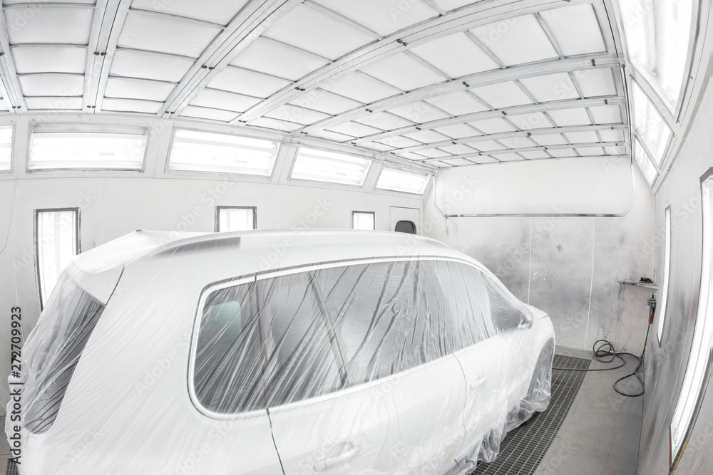 Garage painting car service. Vehicle is covered with protective paper.  Repairing car body work after the accident by working sanding primer before  painting. Stock Photo | Adobe Stock