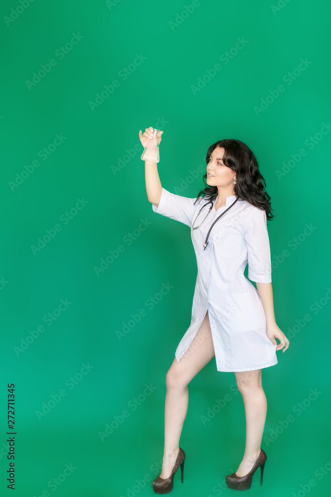 Girl nurse in the laboratory holding a flask, examines the contents, on a green screen background Girl nurse in the laboratory holding a flask, examines the contents, on a green screen background