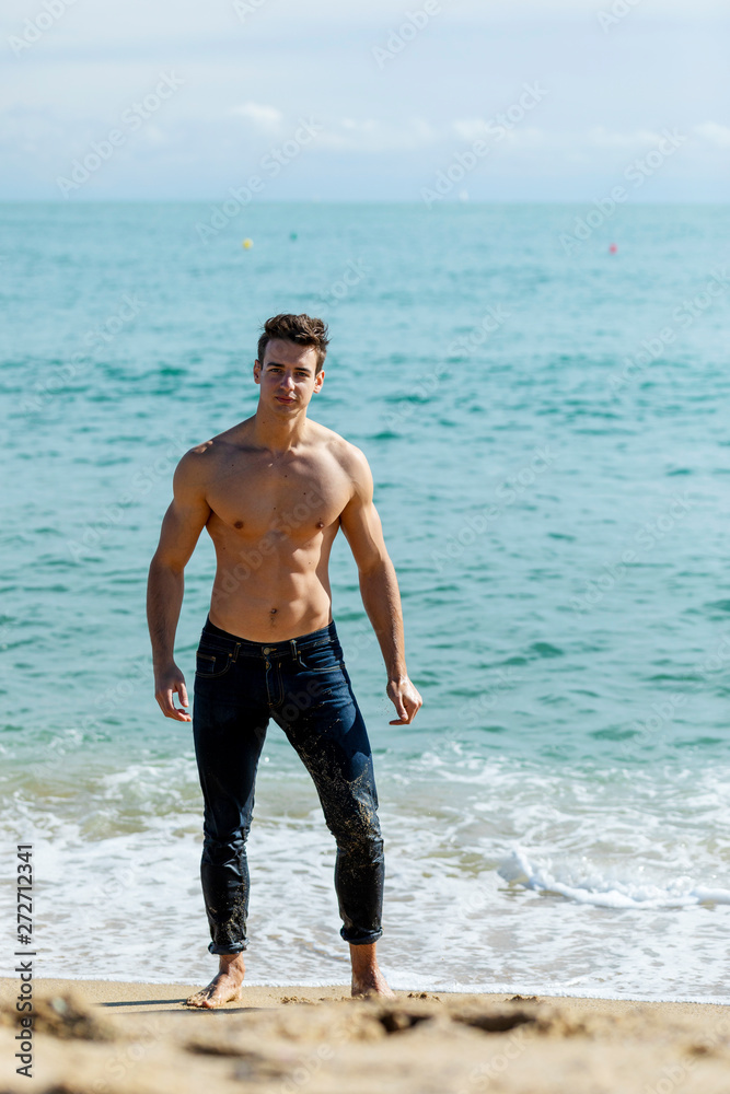 Young handsome muscular man on seashore in a sunny day Young handsome muscular man on seashore in a sunny day