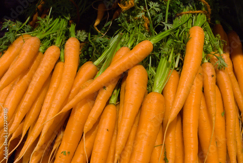 closeup of a stack of orange carrots in the supermarket