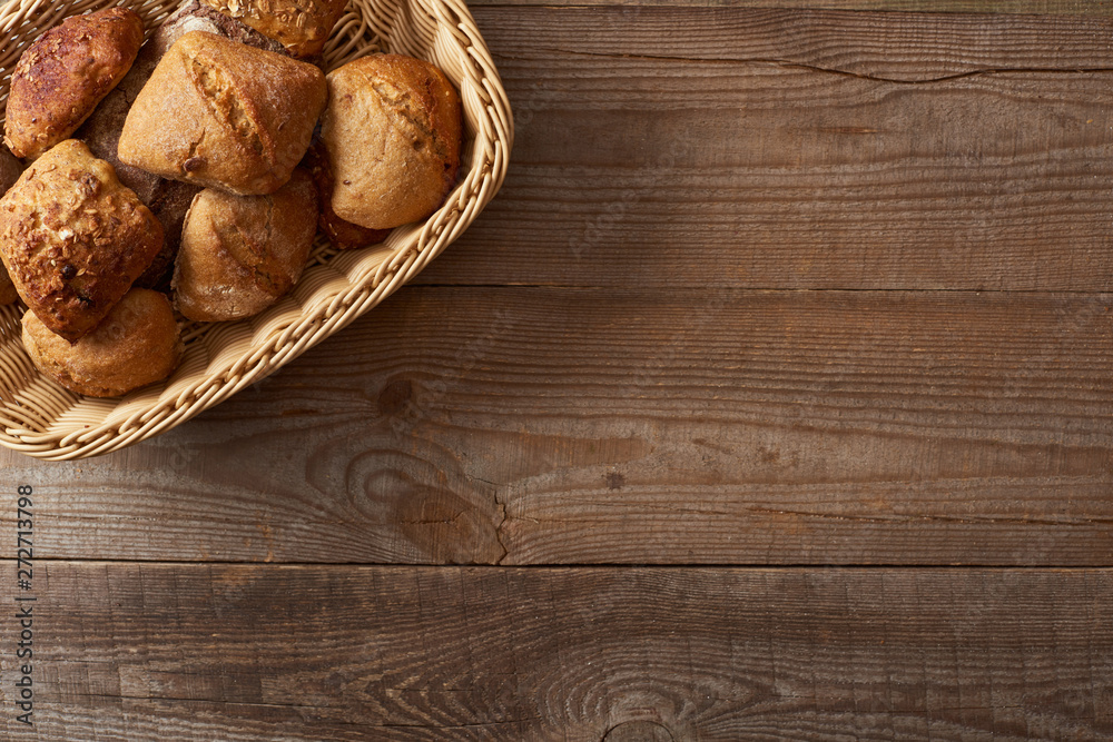 top view of wicker basket with buns on wooden table