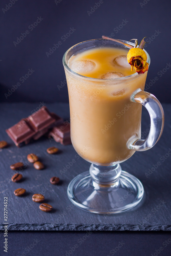 Copper coffee pot (Cezve) and coffee beans. Coffee with milk on dark background. Latte and black chocolate on slate board. Milk drink in glass beaker and dried rose Copper coffee pot (Cezve) and coffee beans. Coffee with milk on dark background. Latte and black chocolate on slate board. Milk drink in glass beaker and dried rose