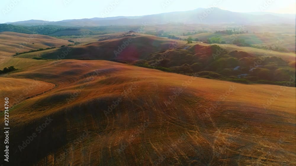 Aerial Cinematic Drone View of a Countryside with Hills and Fields. Background with Rural Green Area with Few Houses. Sunny Clear Day. Aerial Cinematic Drone View of a Countryside with Hills and Fields. Background with Rural Green Area with Few Houses. Sunny Clear Day.