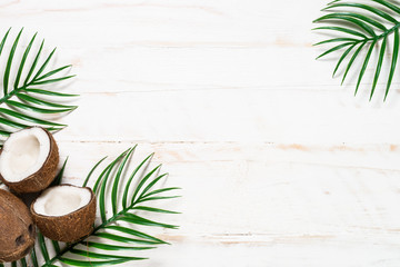 Palm leaves and coconut on whitee top view.