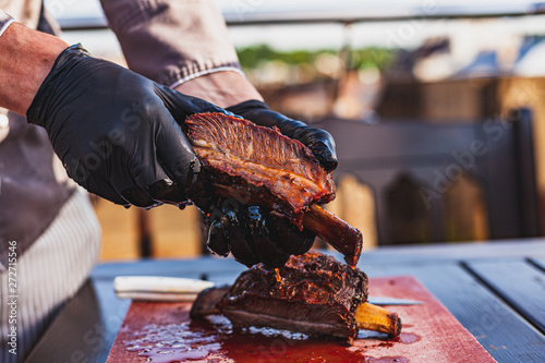 Chef holding cutted juicy slow cooked meat in hands