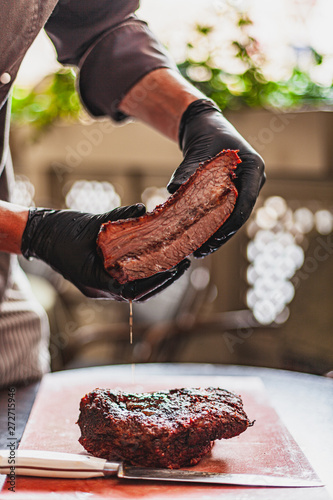 Chef holding cutted juicy slow cooked meat in hands