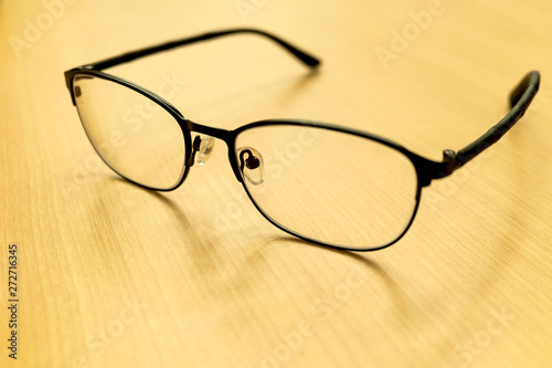 Selective focus eyeglasses on the wooden table background, glasses placed on the table