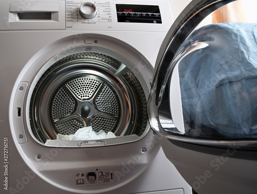 Laundry dryer door open with linen. © lapis2380