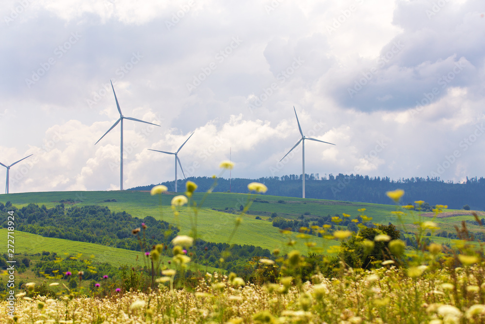 Wind turbines on beautiful sunny summer autumn mountain landsape.