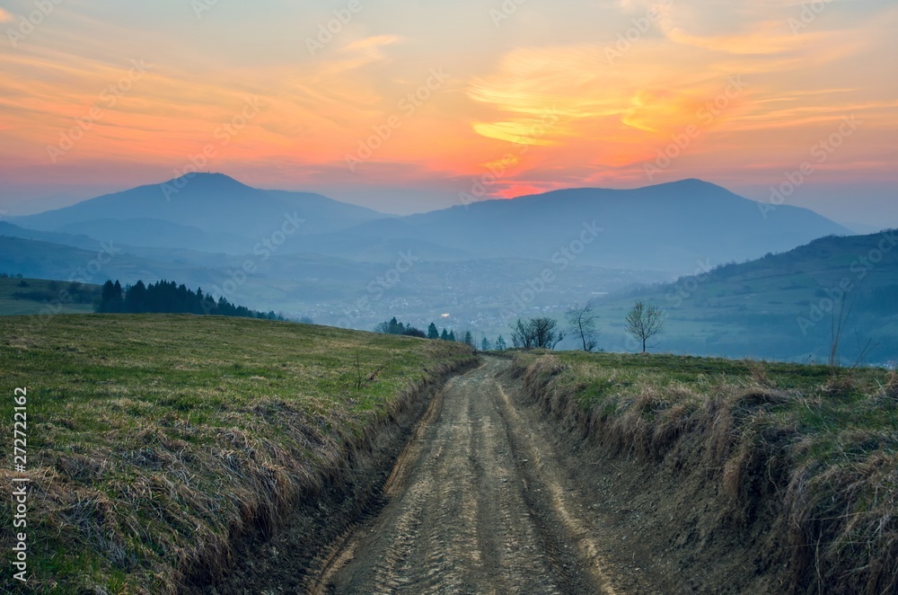 Beautiful mountain colorful landscape. Country road and sunset over the hills.