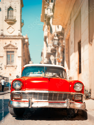 Classic red car on a narrow street in Old Havana