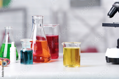 Different glassware with samples on table in chemistry laboratory