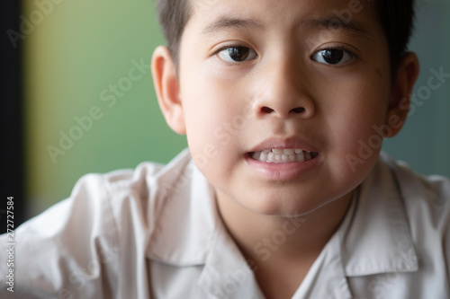 Close up asian boy showing feeling, isolated on blur background.