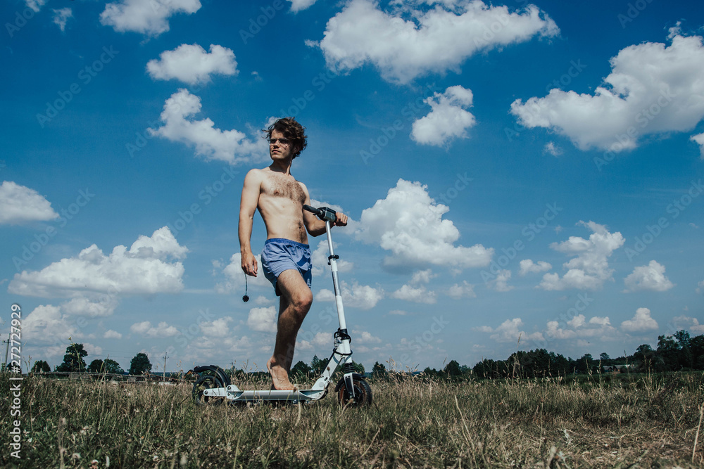 Young male on the beach an electric scooter driver on a sunny day. Stock  Photo | Adobe Stock