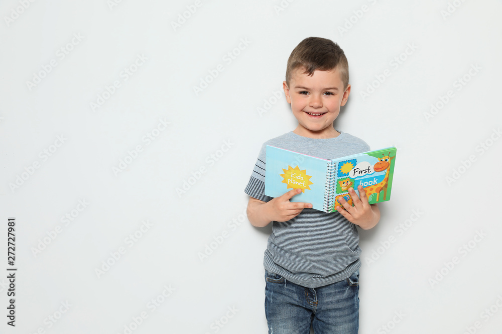 Cute little boy reading book on white background, space for text Cute little boy reading book on white background, space for text