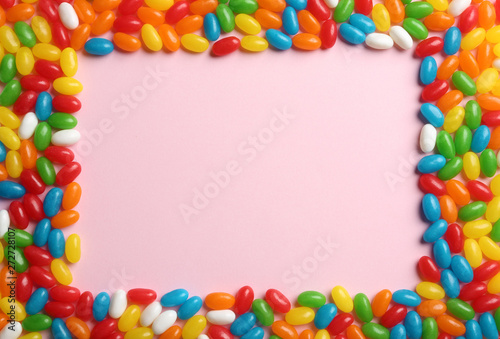 Flat lay composition with delicious jelly beans on light background. Space for text