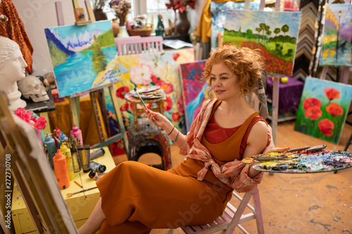 Принти на полотні Promising artist sitting and looking at her picture