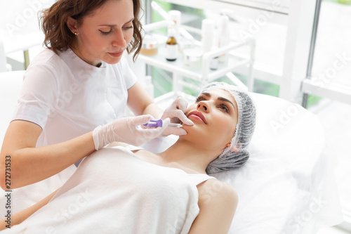 Pleasant adult woman receiving injection in the chin