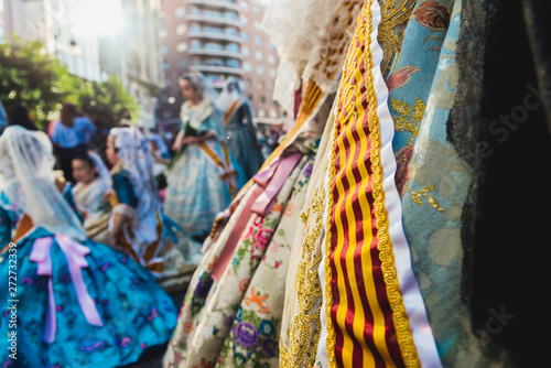 Valencia, Spain - March 17, 2019: Banda and Valencian flag decorating the typical Valencian fallera dress, worn by the beautiful women of Fallas. photo