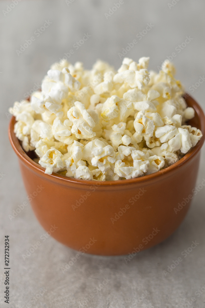 Ceramic bowl with popcorn on gray background Ceramic bowl with popcorn on gray background