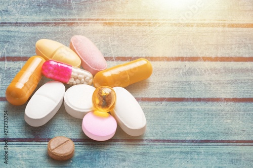 Colorful Pills, Capsules and Tablets on wooden desk
