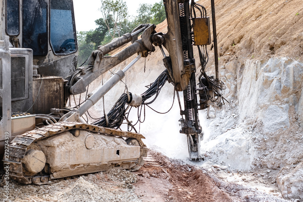 Fototapeta premium Rock driller on road comnstruction. Drilling rock in the works of creating a road.