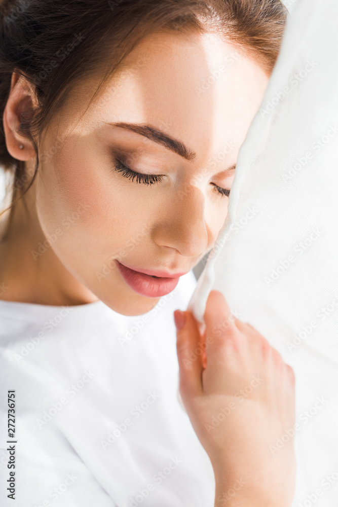 selective focus of pretty young woman with closed eyes in white t-shirt