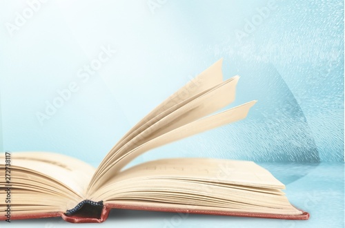 Open book on old wooden table.