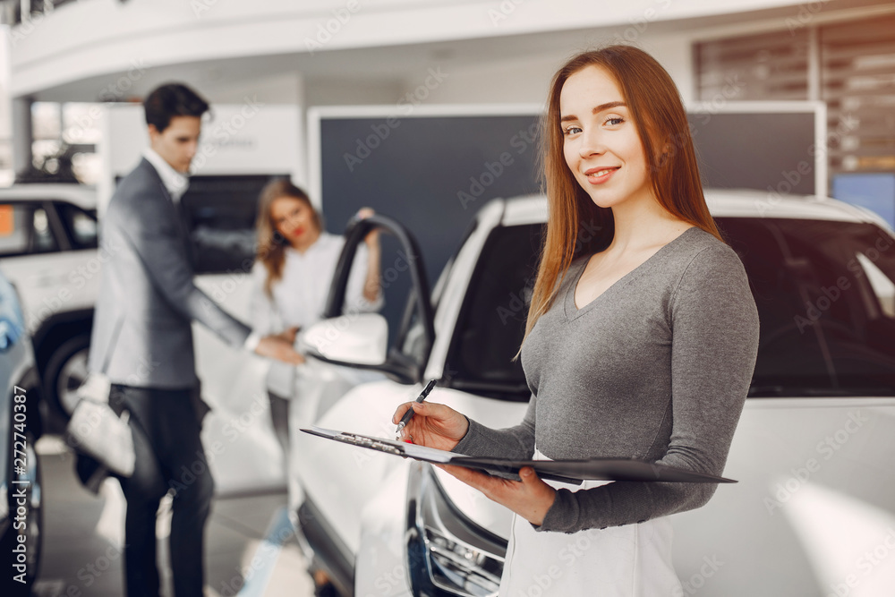 Woman buying the car. Lady in a car salon. Manager with a clients