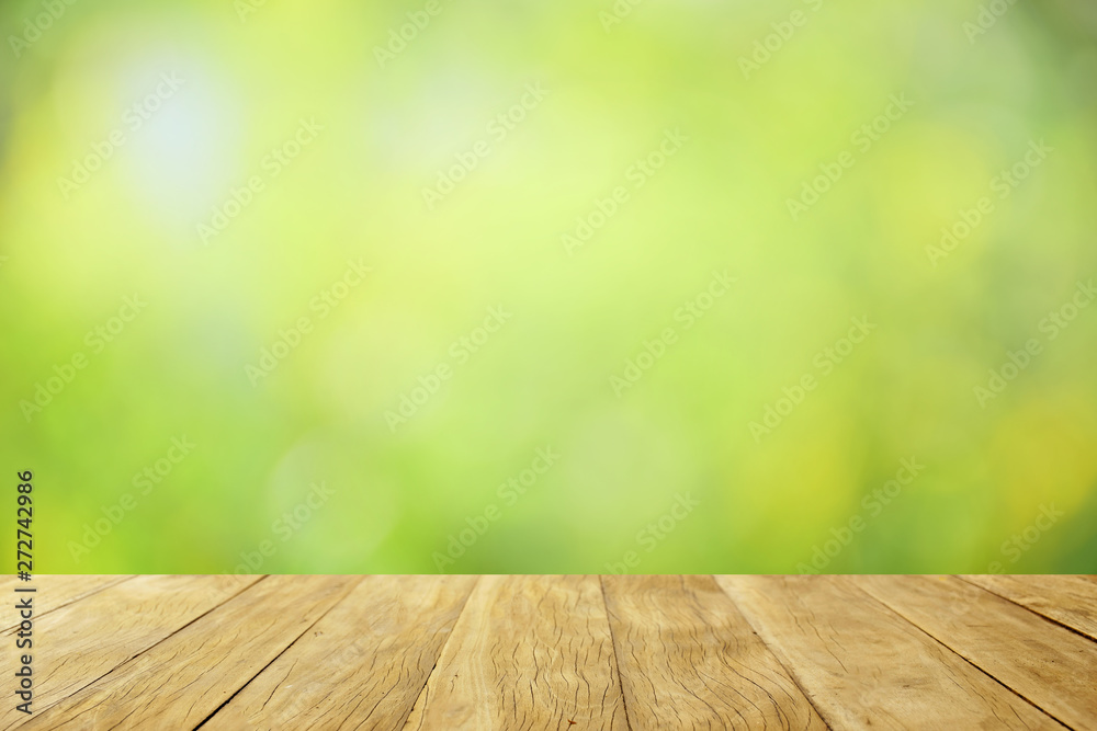 Empty top wooden table on soft blurred green trees for background