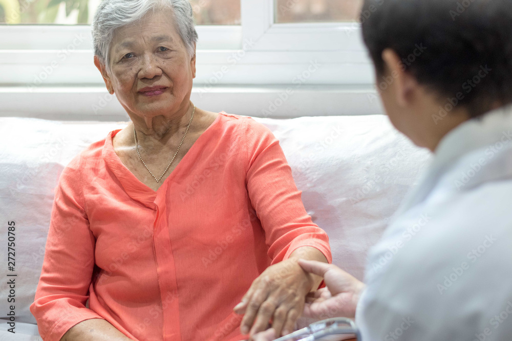 Obraz premium Parkinson and Alzheimer female senior elderly patient with caregiver in hospice care. Doctor hand with stethoscope check up older woman people. Old aging person seeing medical physician in hospital.