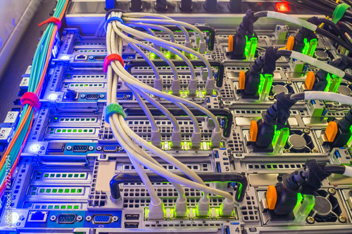Network wires connect to the high-speed interfaces of the main router. High performance data center. Central hosting platform of powerful computer equipment. Back panel of modern web servers close up.