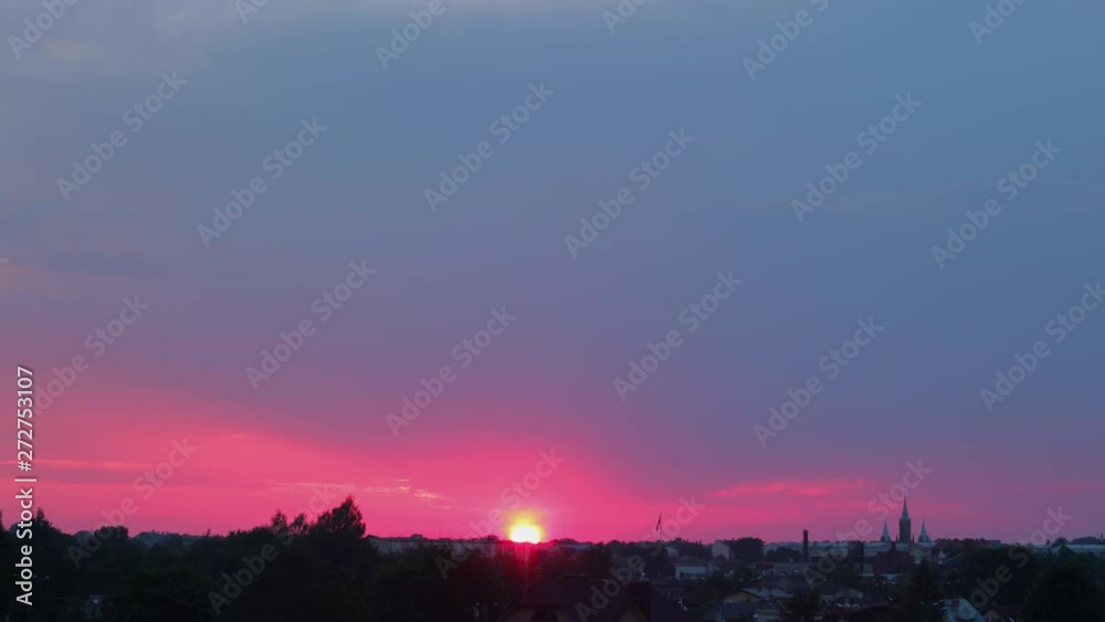 Time lapse of beautiful scenic red sunset over the city with sun shining through the clouds, wide shot Time lapse of beautiful scenic red sunset over the city with sun shining through the clouds, wide shot