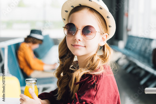 Cuadro en lienzo cute preteen kid in sunglasses sitting with orange juice in waiting hall