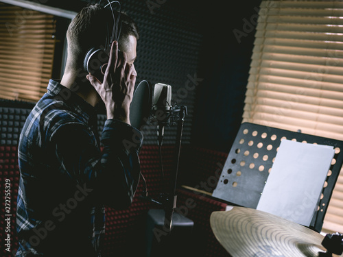 The young guy singing in recording studio