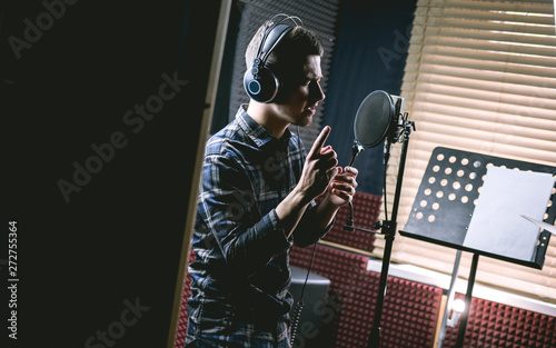 The young guy singing in recording studio