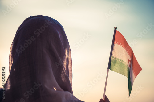 Muslim woman in scarf with Iranian flag at sunset.Concept photo