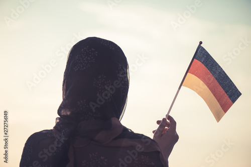 Canvas Print Muslim woman in scarf with Germany flag of at sunset.Concept