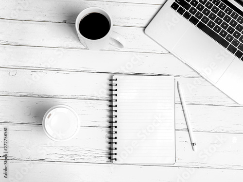 Office desk table with computer, supplies, cup of coffee. White wooden background. Coffee break, ideas, notes, goals or plan writing concept. Top view, flat lay. photo