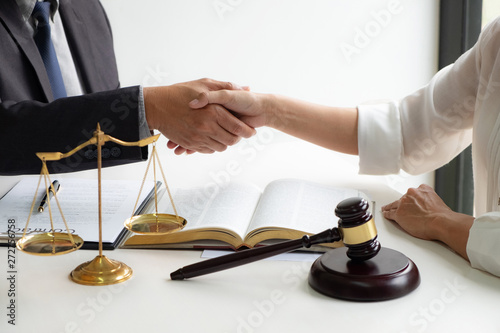 lawyer consultant with client shaking hands together with contract agreement.
