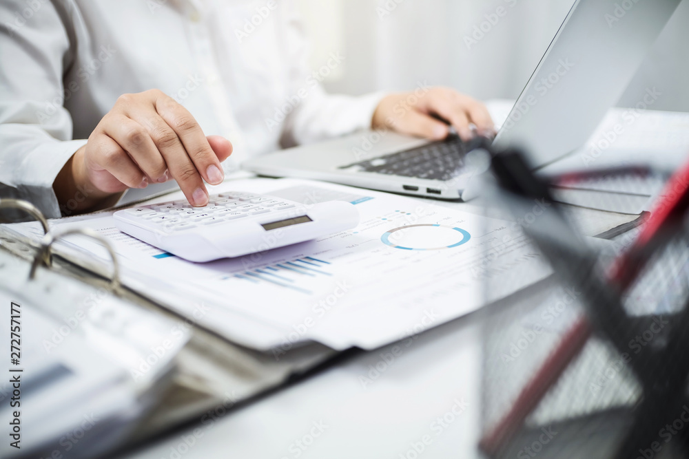 Accountant working with data documents calculating on business report. Accountant working with data documents calculating on business report.