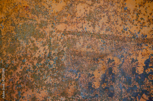 old shabby iron surface with rust and remnants of orange paint