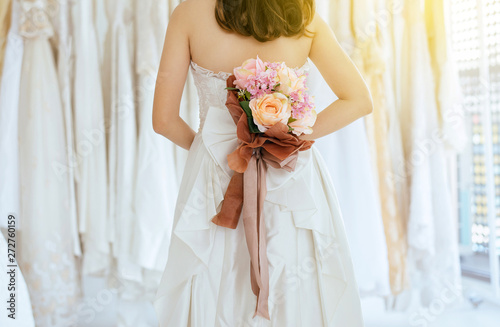 Close up of bride woman hand holding a bouquet behide her back for wedding,Romantic and sweet moment