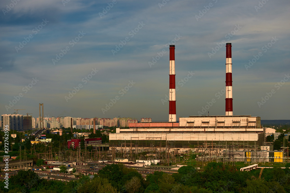 power plant with pipes on evening sky background