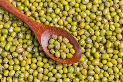 Green beans in woodspoon on green beans background photo
