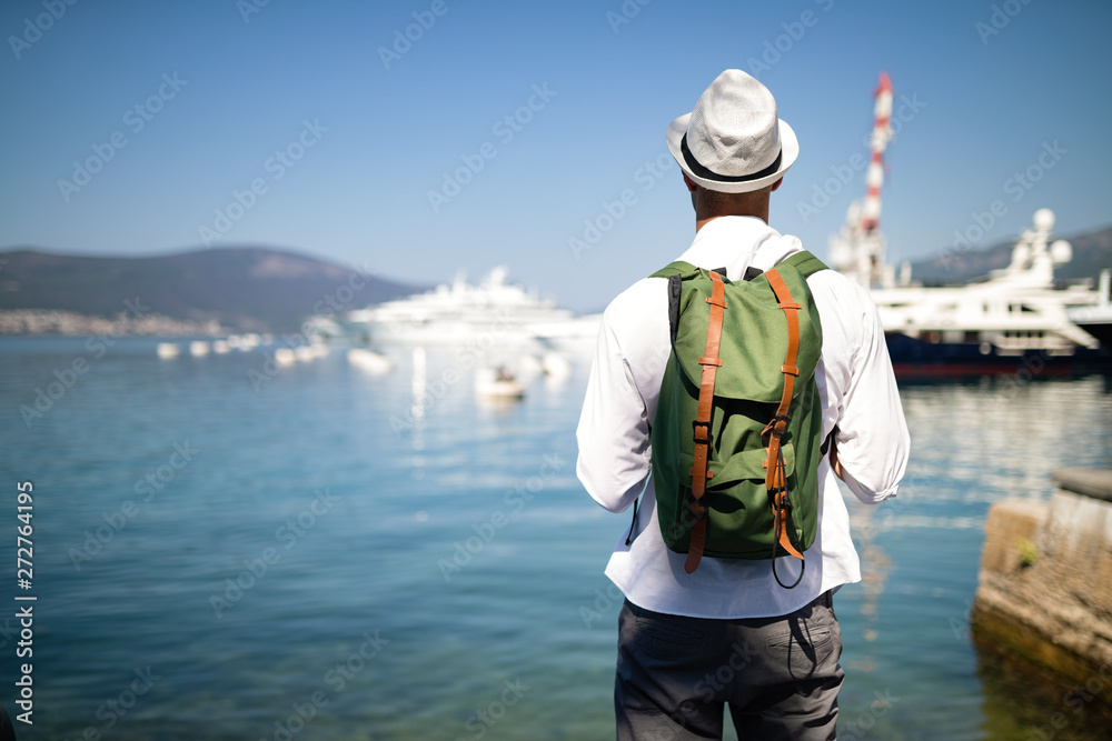 Vacation, holidays, travel, sea and people concept. Man with backpack enjoying travelling