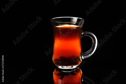 A glass of Turkish black tea on the black background